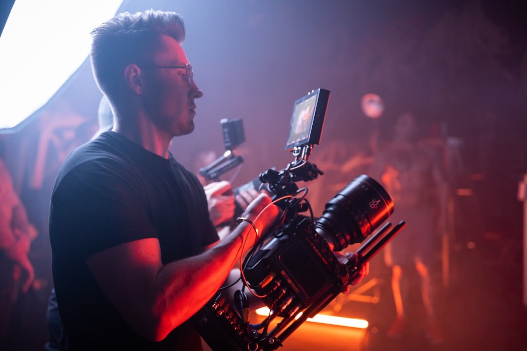Camera operator filming a live event with a broadcast camera