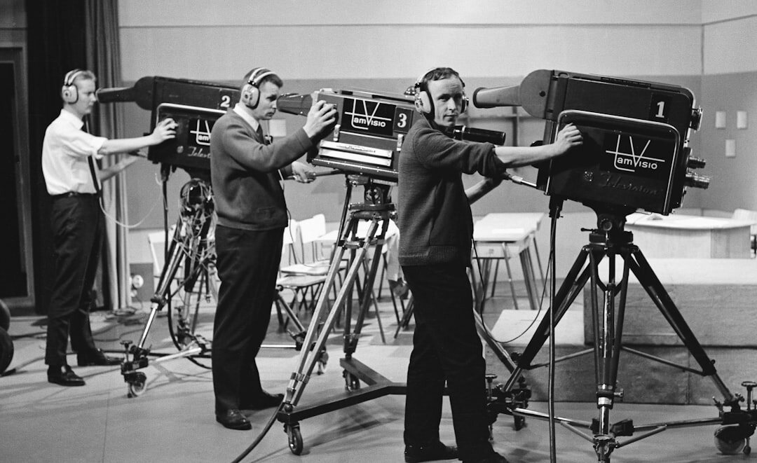 TV studio with multiple broadcast cameras pointed at a presenter desk